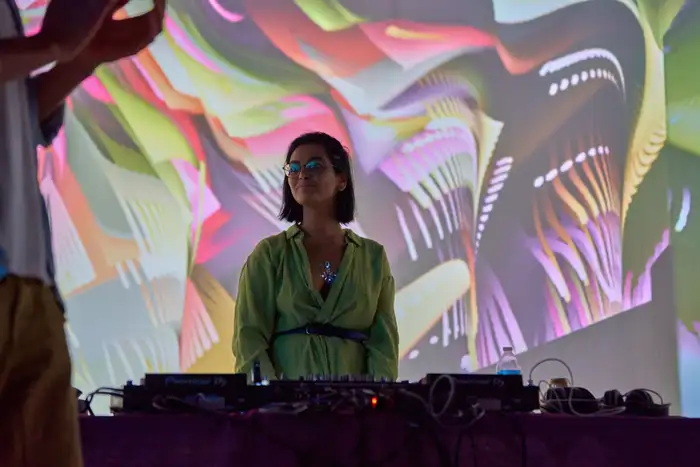 A musician performing in front of a wall-sized projected artwork